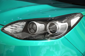 close-up of the front headlight of a new modern colored car. new clean mint car