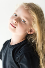 portrait of beautiful kid with long curly hair looking at camera isolated on white