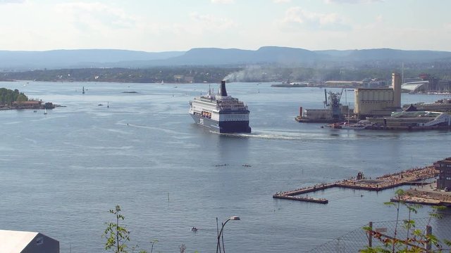 DFDS ferry going out of Oslo port with public beach and port and opera house and museums on background