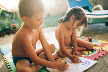 Little boy and girl drawing with crayons