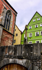 Scene from Rothenburg Ob Der Tauber, showing beautiful painted, timber framed, buildings and part of the stone cathedral. Taken on a cloudy day.