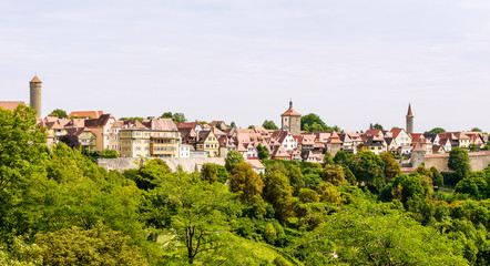 Fototapeta na wymiar Scene from Rothenburg Ob Der Tauber, showing the whole city from far away, with the city wall, watch towers and houses visible.