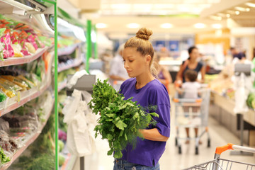 Woman smelling lettuce in the supermarket