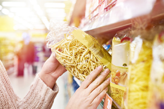 Pack of pasta in hands of buyer at store