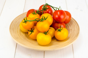 Ripe juicy tomatoes on large wooden plate