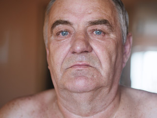 Aged man portrait on light background.