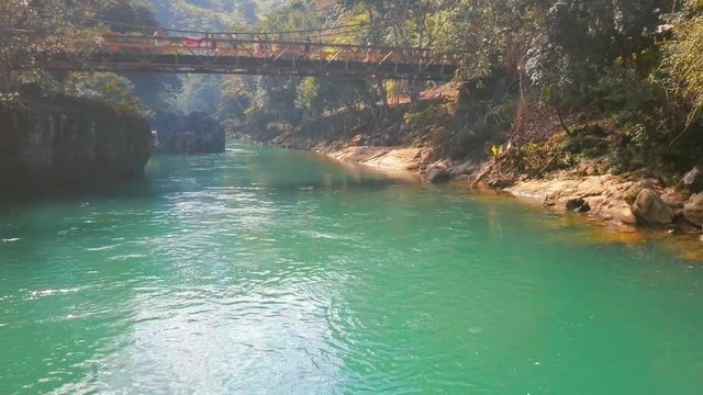 Flying over the river towards a pedestrian footbridge in Semuc Champey, Guatemala