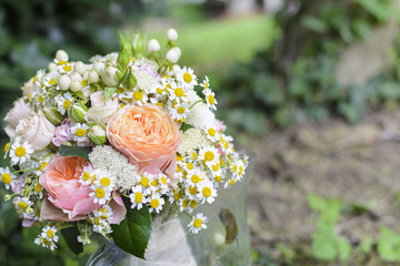 Obraz na płótnie Canvas Bridal bouquet with rose, daisy, against forest background.