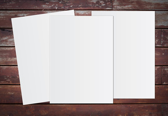 Blank white paper on brown wooden background for text input.