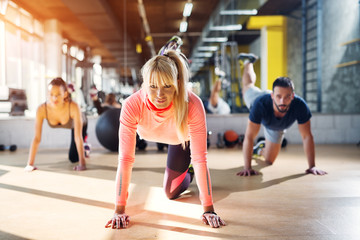Young strong female gym instructor showing some body balance work out.