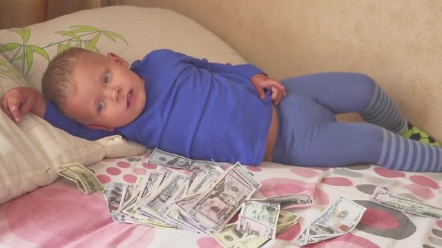 sleeping baby and falling money. Concept unexpected wealth. A big win.