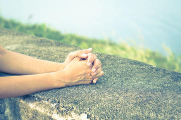 Girl claps or praying on rock table.