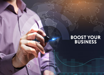 The concept of business, technology, the Internet and the network. A young entrepreneur working on a virtual screen of the future and sees the inscription: Boost your business