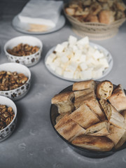 tasty georgian cheese, walnuts and pieces of bread on table in kitchen