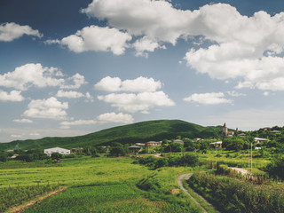 Fototapeta premium beautiful green fields, hills and cloudy sky near village in georgia