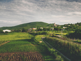 Fototapeta premium beautiful green fields, road and hills near village in georgia
