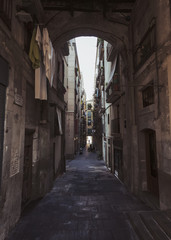 Fototapeta na wymiar Narrow street in Gothic Quarter with hanging clothes on balcony on Barcelona, Spain