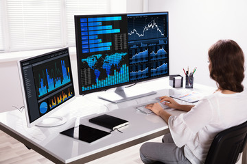 Stock Market Broker Analyzing Graphs On Computer