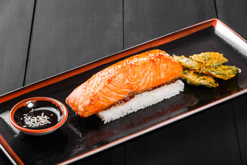 Baked fillet salmon with rice and physalis on wooden background. Hot fish dish. Top view