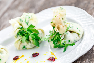 Stuffed pancakes or bags of pancakes with herbs on plate on rustic table. Healthy food