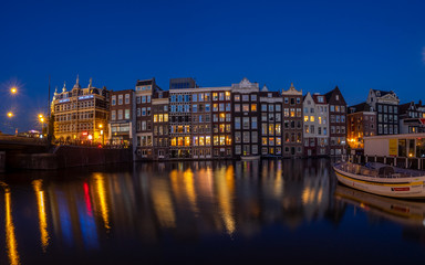 Fototapeta na wymiar Historic buildings on the Damrak canal in the centre of beautiful Amsterdam at night.
