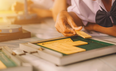 Education concept.children, technology, science and people concept. hand holding a square tangram puzzle, over wooden table.