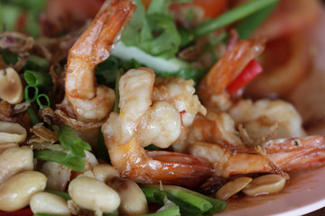 Fried spicy shrimp with peanut decorated with red chili and green leaf, gourmet menu recipe from Asian restaurant