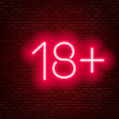Eighteen plus neon sign on brick wall background.