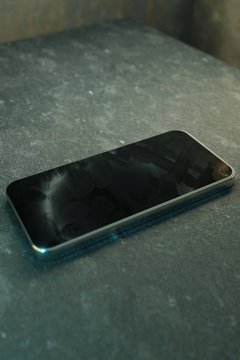 Fingerabdrücke und Schmutzflecken auf Display eines schwarzen Smartphones. 3D Rendering