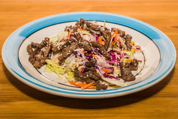 Delicious salad of fresh vegetables with spices on a plate. European Cafe