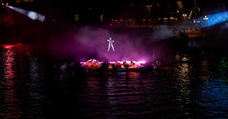 Hanging acrobat with the performance below in purple light