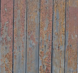 Old aged wooden fence with damaged brown paint