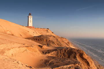 Aerial view of the giant sand dunes with the famous lighthouse on the top of a hill. Rubjerg Knude Lighthouse, Lønstrup in North Jutland in Denmark, Skagerrak, North Sea - obrazy, fototapety, plakaty