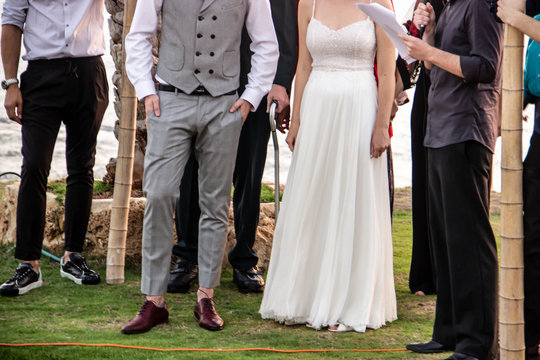 Happy young people hold hands on the background of the sea