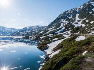Snow melting by mountain lake