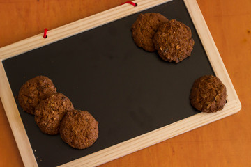 Oatmeal and chocolate with a fruit filling biscuits lies on a wo