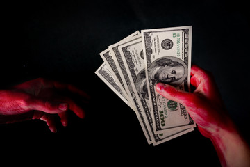 hungred dollar bills in blood on dark background