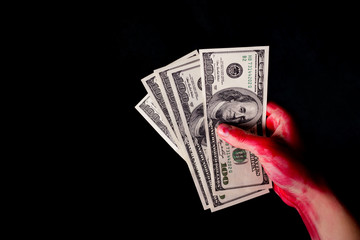 hungred dollar bills in blood on dark background