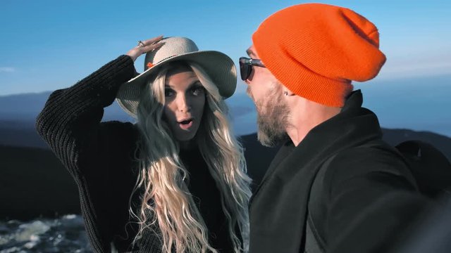 Pov shot traveler couple in hat posing smiling sending air kiss and pulling face taking selfie