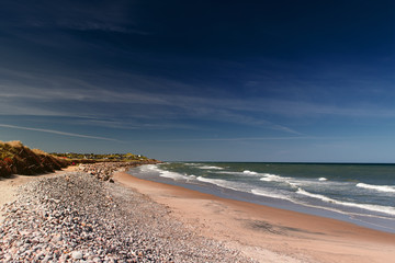 View of the beautiful beach coastline with dunes and stones in Northern Denmark are perfect for summer holidays. Danish Beach, Lønstrup in North Jutland in Denmark, Skagerrak, North Sea