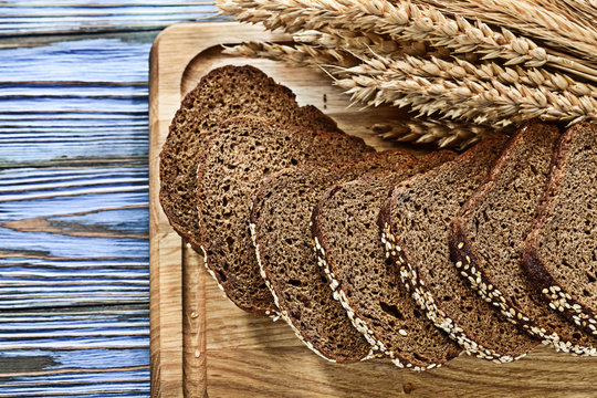 Wheat ears chopping board sliced brown bread on vintage wooden b