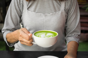 Matcha green tea latte in hand.