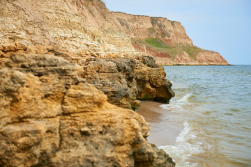 Fototapeta na wymiar beautiful sea landscape, closeup of stone on the beach, sea coast with high hills, wild nature