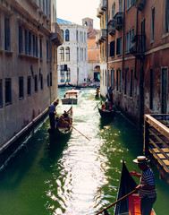 Fototapeta na wymiar Gondola with passengers floats on small Venice canal. Canal Grande, Venice, Italy