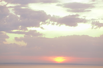 Beautiful sunset with clouds of orange and yellow in the ocean, the river