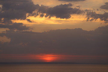Fototapeta na wymiar Beautiful sunset with clouds of orange and yellow in the ocean, the river