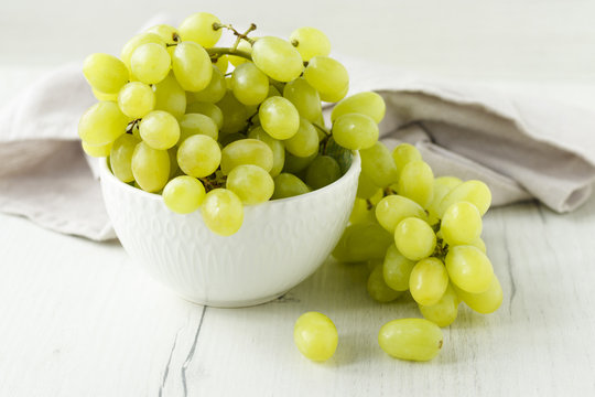 a bunch of grapes on a wooden background