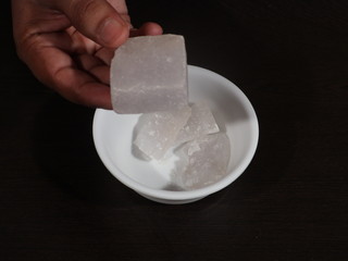 Alum in Hand. Fitkari in Wooden Background