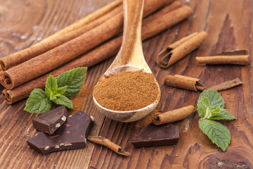 Cinnamn powder and sticks, chocolate, and mint leaves.