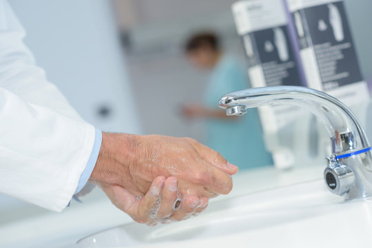 close up of doctor washing his hands